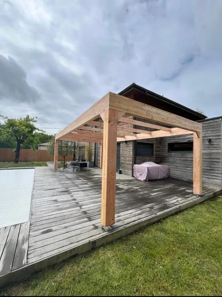 Pergola bois Gironde posée sur terrasse piscine — structure sur-mesure après aménagement extérieur Nouvelle-Aquitaine