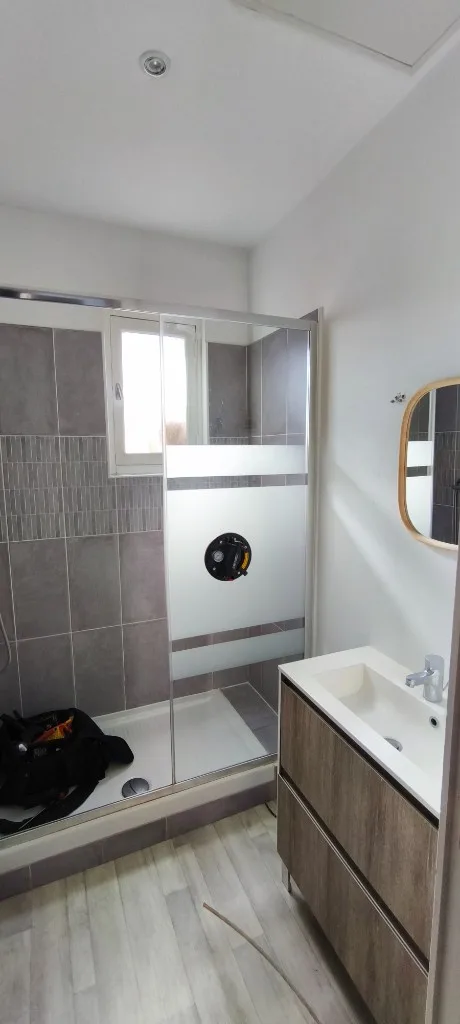Salle de bain en cours : paroi dépolie et robinetterie non posée
